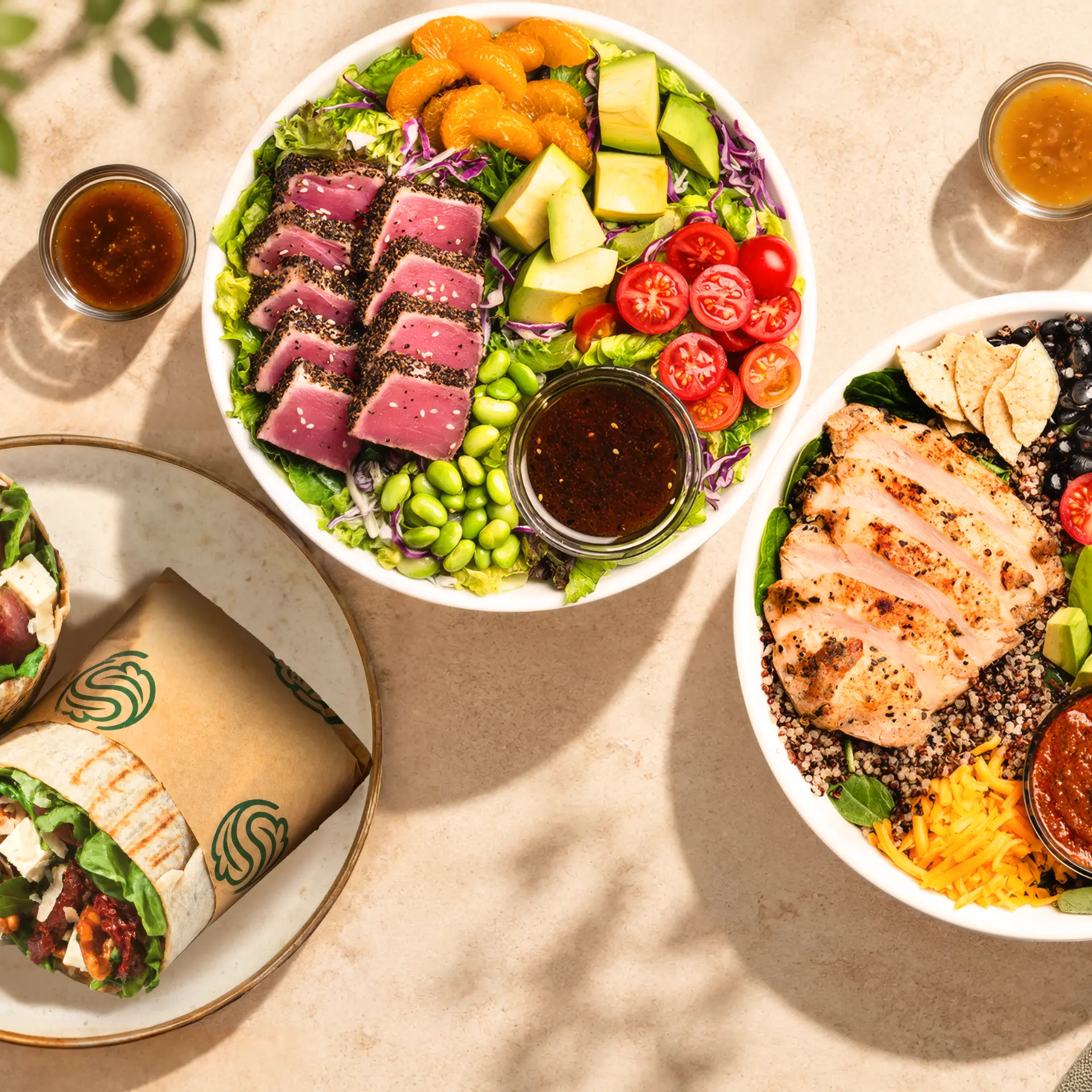 SaladStop! bowls with seared tuna, grilled chicken and wraps, seen from above