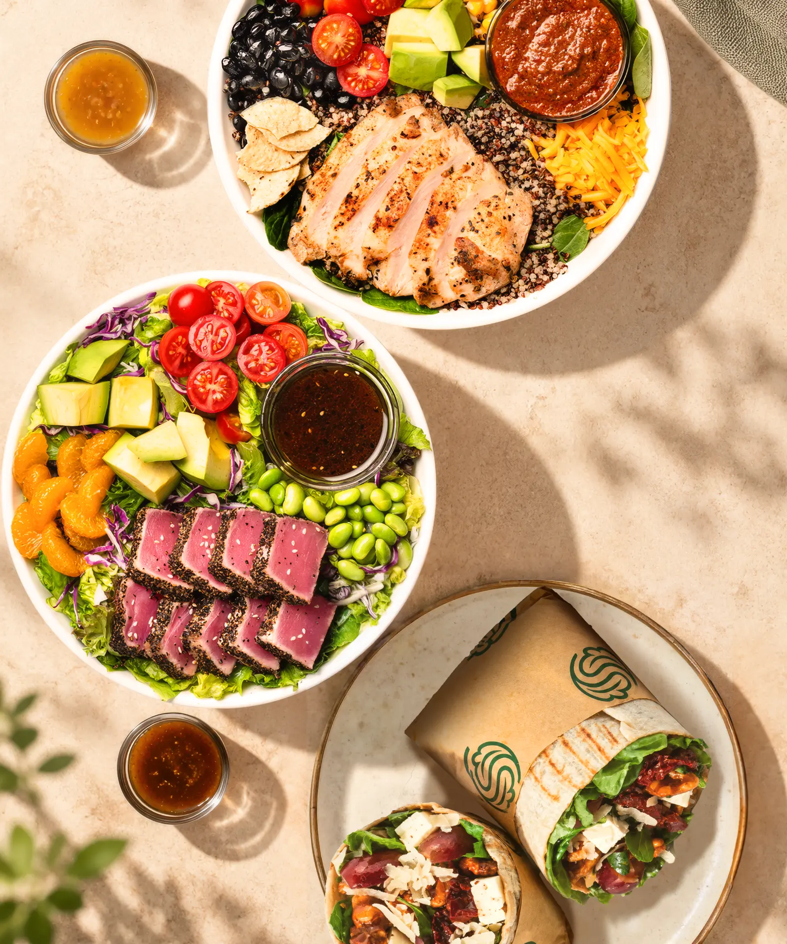 SaladStop! bowls with seared tuna, grilled chicken and wraps, seen from above